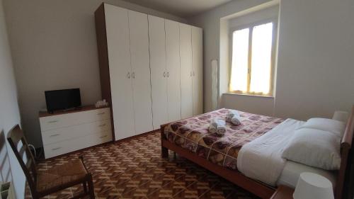 1 dormitorio con 1 cama, vestidor y TV en Appartamento Via Ponchielli, en Perugia