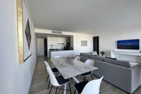a living room with a couch and a table and chairs at Top floor, amazing sea view in Puerto Cancun in Cancún