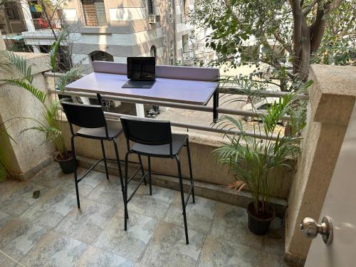 a table and chairs on a balcony with a laptop at The Good Vibes Studio : AC, WiFi, Smart Tv in Pune