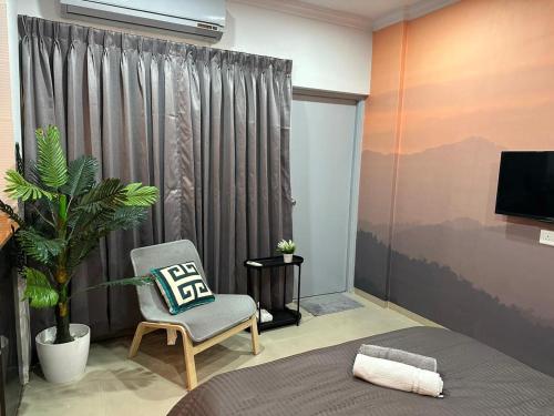 a bedroom with a bed and a chair and a television at The Good Vibes Studio : AC, WiFi, Smart Tv in Pune