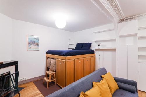 ein Wohnzimmer mit einem blauen Sofa und einem Kamin in der Unterkunft Studio Tour Eiffel Garibaldi in Paris
