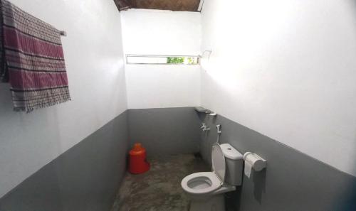 niewielka łazienka z toaletą i oknem w obiekcie Oronner Din Ratri w mieście Sreemangal
