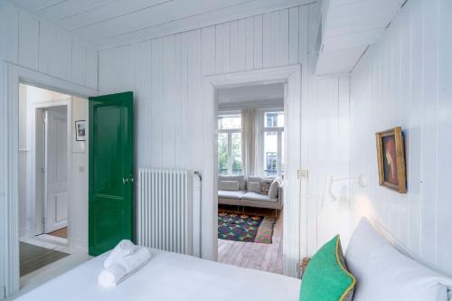 - une chambre avec un lit et une porte verte dans l'établissement The Handshake House, à Anvers