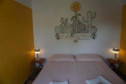 1 dormitorio con 1 cama con una pegatina de cactus en la pared en Sunflower City Student Hostel & Bar, en Rímini