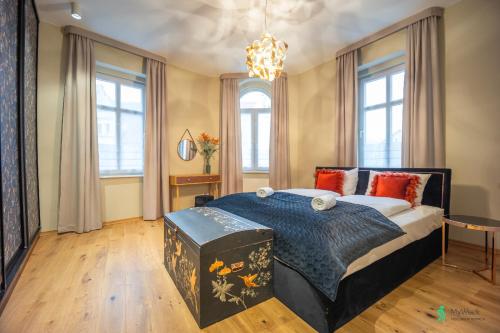 um quarto com uma cama grande e um lustre em Apartamenty z Duszą, MyWeek em Duszniki Zdrój