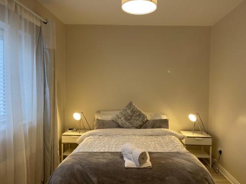 una camera da letto con un letto e un asciugamano sopra di Letterkenny Three Bedroom Town Centre Apartment a Letterkenny