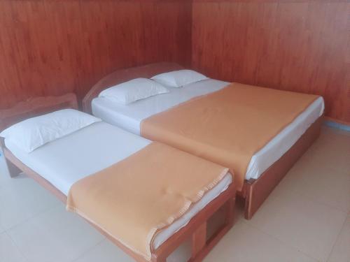 2 camas individuales en una habitación con pared en Budget comfort en Madikeri