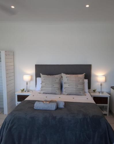 a bedroom with a large bed with two lamps at Studio @ 32 in Ballito