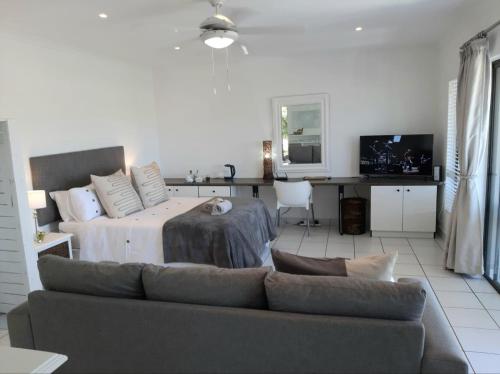 a living room with a bed and a couch at Studio @ 32 in Ballito