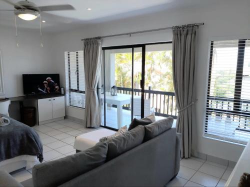 a living room with a couch and a balcony at Studio @ 32 in Ballito