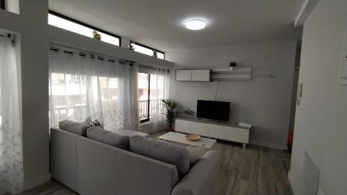 ein Wohnzimmer mit Sofa und Fernseher in der Unterkunft Apartamento El Puerto del Médano in El Médano