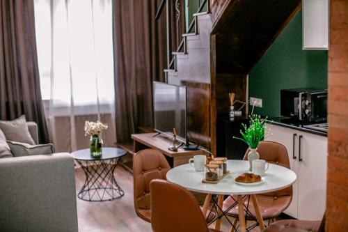 a living room with a white table and a kitchen at Luxury Duplex Studios - City Center in Tbilisi City