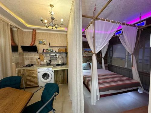 Cet appartement comprend une chambre avec un lit et une table ainsi qu'une cuisine. dans l'établissement City Center Beach side Hut, à Tbilissi