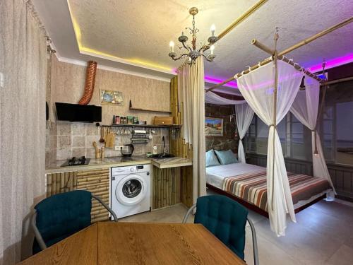 a kitchen with a table and a bed in a room at City Center Beach side Hut in Tbilisi City