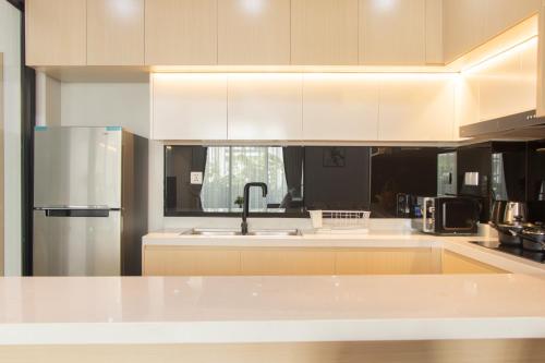 a kitchen with white cabinets and a stainless steel refrigerator at Sky Park Condotel & Residence in Siem Reap