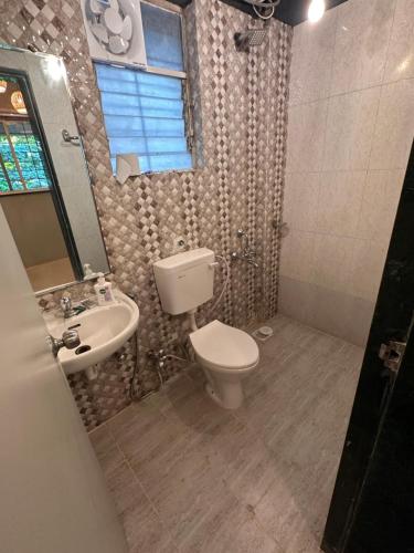 a bathroom with a toilet and a sink at The Studio: AC, WiFi, Smart Tv in Pune