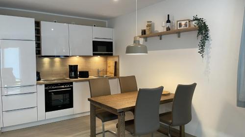 a kitchen with a wooden table and a kitchen with white cabinets at Ferienwohnung Am Wall in Radeberg