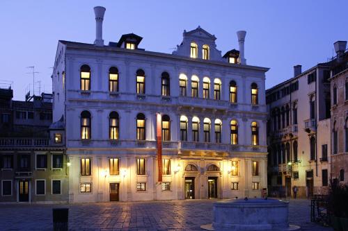 un grand bâtiment avec ses lumières allumées la nuit dans l'établissement Ruzzini Palace Hotel, à Venise