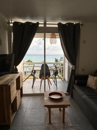 a living room with a view of the ocean at Bohème créole in Le Diamant