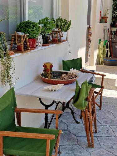 a table with green chairs and a bowl on it at Anna's in Politiká