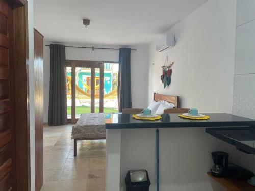 a kitchen with a counter top and a living room at BRISAS DE FORTIM VILLAGE in Fortim