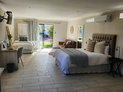 a bedroom with a large bed and a living room at On Enslin selfcatering in Middelburg