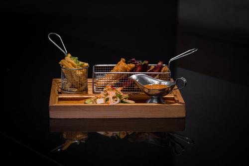 a tray of food on a table with a basket of food at Indaba Lodge Gaborone in Gaborone