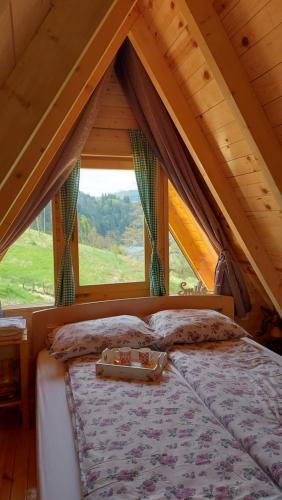 uma cama num quarto com uma grande janela em Tarska čarolija Zaovine em Popovići