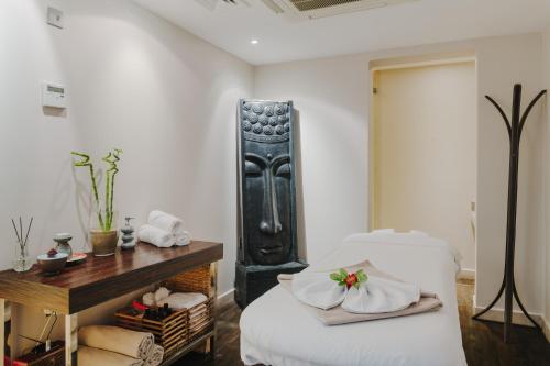 a bedroom with a bed and a table with towels at Arkin Palm Beach Hotel in Mağusa