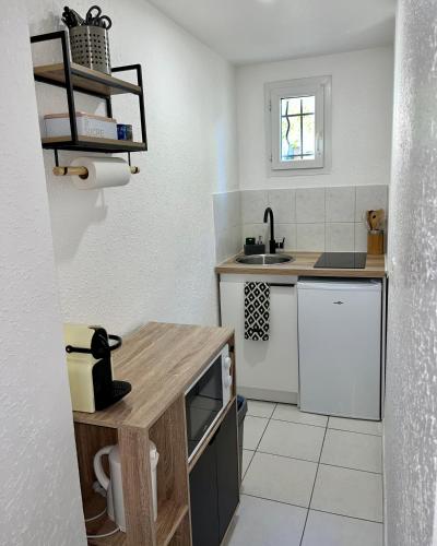 une petite cuisine avec un comptoir et un évier dans l'établissement Appart'Terracotta - Au cœur de Lorgues, à Lorgues