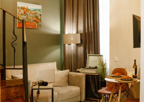 a living room with a couch and a table with a laptop at Luxury Duplex Studios - City Center in Tbilisi City