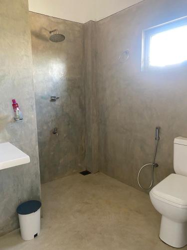 een badkamer met een toilet en een douche bij Heimat Hugs in Habaraduwa Central
