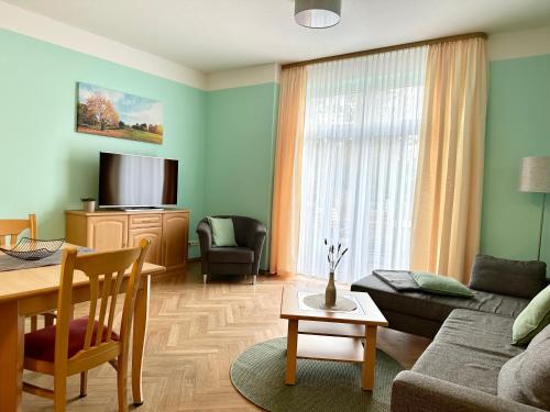 ein Wohnzimmer mit einem Sofa und einem Tisch in der Unterkunft Hotelpark Bodetal "große Ferienwohnung" in Thale