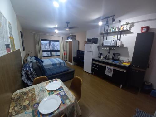 een woonkamer met een tafel en een keuken bij Lindo Apartamento na Frei Caneca in Sao Paulo