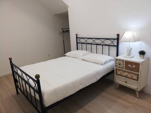 um quarto com uma cama preta e uma mesa de cabeceira com um candeeiro em Azores Calheta Inn T2 Frente Boa Nova em Ponta Delgada