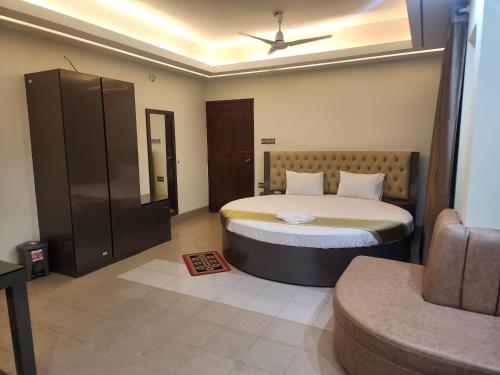 una camera con un letto e un divano di Urmee Guest House a Cox's Bazar