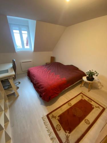 een slaapkamer met een rood bed en een tafel en een piano bij Superbe Duplex Strasbourg in Schiltigheim