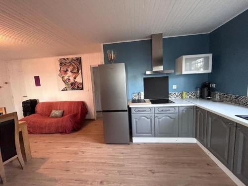 Il comprend une cuisine équipée d'un réfrigérateur et d'un canapé rouge. dans l'établissement Bel appartement vue mer., aux Issambres