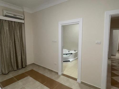 een kamer met een spiegel en een kamer met een bad bij Moubark 6 Villa 6 in Hurghada