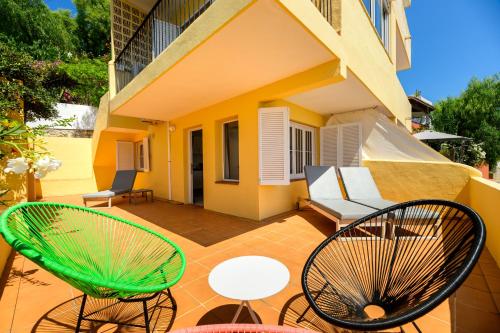 eine Terrasse mit Stühlen und Tischen sowie ein Gebäude in der Unterkunft Hotel Cenit & Apts. Sol y Viento in Ibiza-Stadt