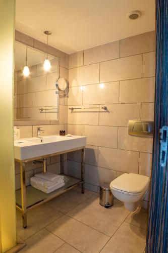 a bathroom with a sink and a toilet at Arkin Palm Beach Hotel in Mağusa