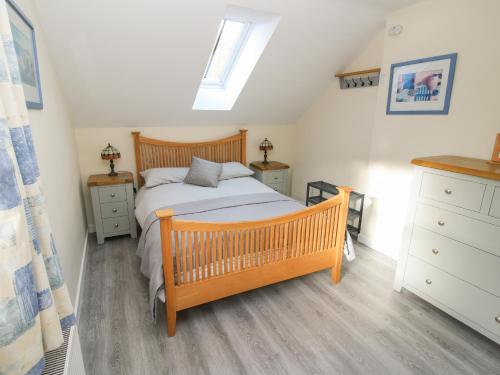 a bedroom with a wooden bed and two night stands at Woodland View in Mold