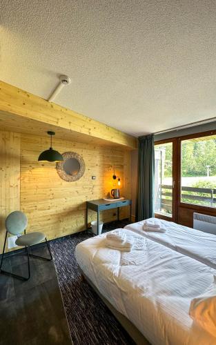 a bedroom with a large bed and a wooden wall at Le Motel du Gaschney in Muhlbach-sur-Munster
