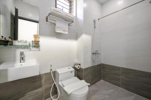 a white bathroom with a toilet and a sink at Moskva Motel & Apartment Danang in Danang