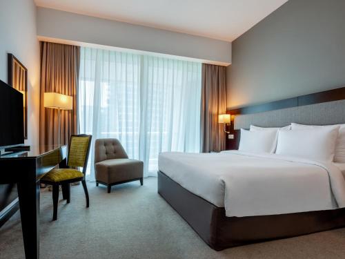 una camera d'albergo con letto, scrivania e sedia di Flora Creek Deluxe Hotel Apartments, Deira a Dubai