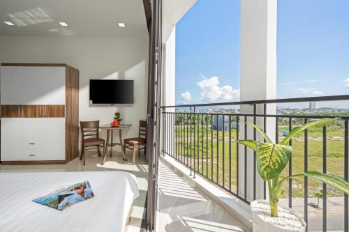 a room with a balcony with a bed and a tv at Moskva Motel & Apartment Danang in Da Nang