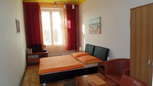 1 dormitorio con cama, escritorio y ventana en Apartments Rokytka - Praha, en Praga
