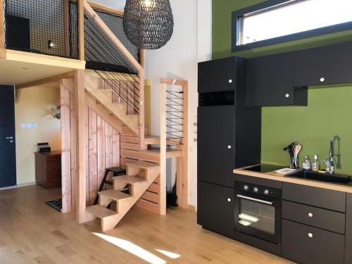 a kitchen with a wooden staircase in a room at dans un esprit cabane tout confort, intimité et nature in Saint Alban Auriolles