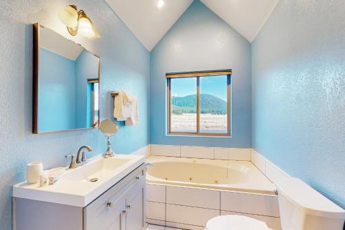 ein Badezimmer mit einer Badewanne, einem Waschbecken und einem Spiegel in der Unterkunft 6555 N Chambers Dr in Flagstaff