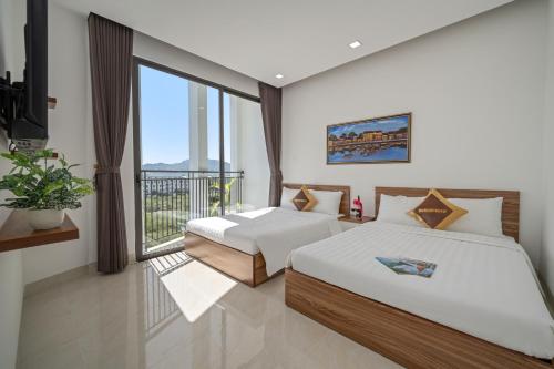 two beds in a room with a balcony at Moskva Motel & Apartment Danang in Danang